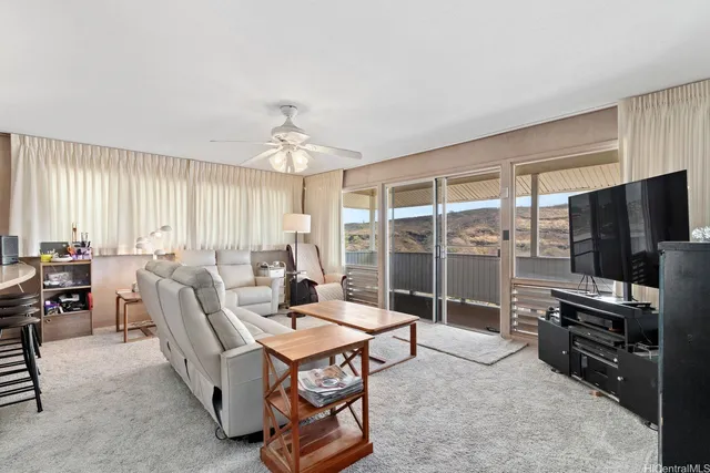 a living room with furniture a flat screen tv and a large window