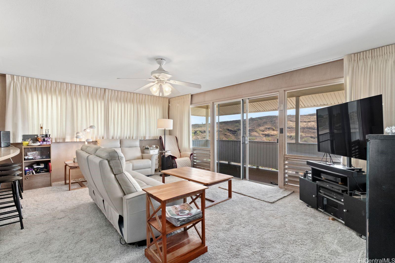 3404 Ala Hinalo Place Honolulu, HI 96818 - Photo 3 of 11 a living room with furniture a flat screen tv and a large window