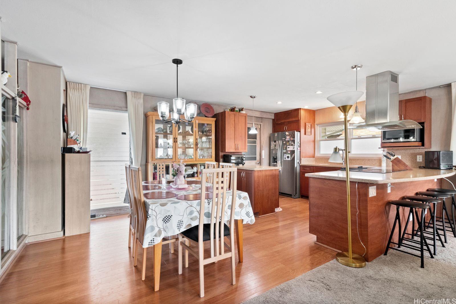 3404 Ala Hinalo Place Honolulu, HI 96818 - Photo 4 of 11 a dining hall with stainless steel appliances kitchen island granite countertop a table chairs and a living room view