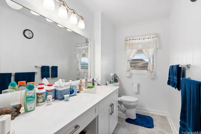 a bathroom with a sink mirror vanity and toilet