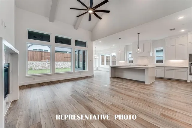 a view of a kitchen with kitchen island wooden floors and stainless steel appliances