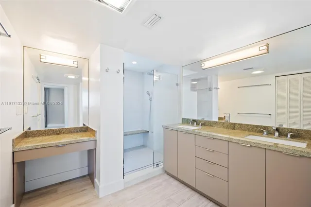 a bathroom with a granite countertop sink mirror and toilet