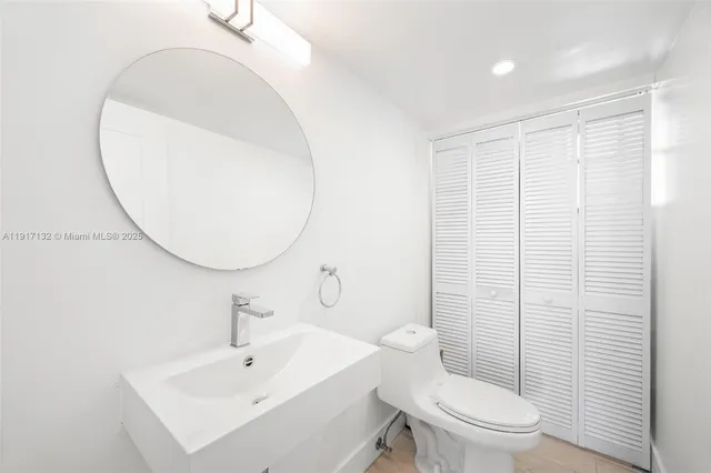 a bathroom with a sink mirror and toilet