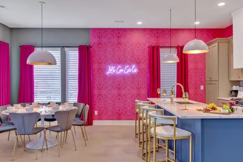 a kitchen with a refrigerator a stove and a dining table with wooden floor