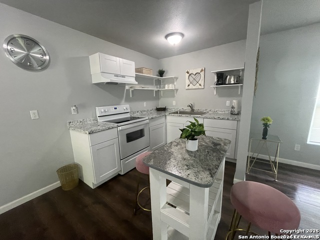422 Florence Street Uvalde, TX 78801 - Photo 5 of 11 a kitchen with stainless steel appliances granite countertop a stove a sink and a refrigerator