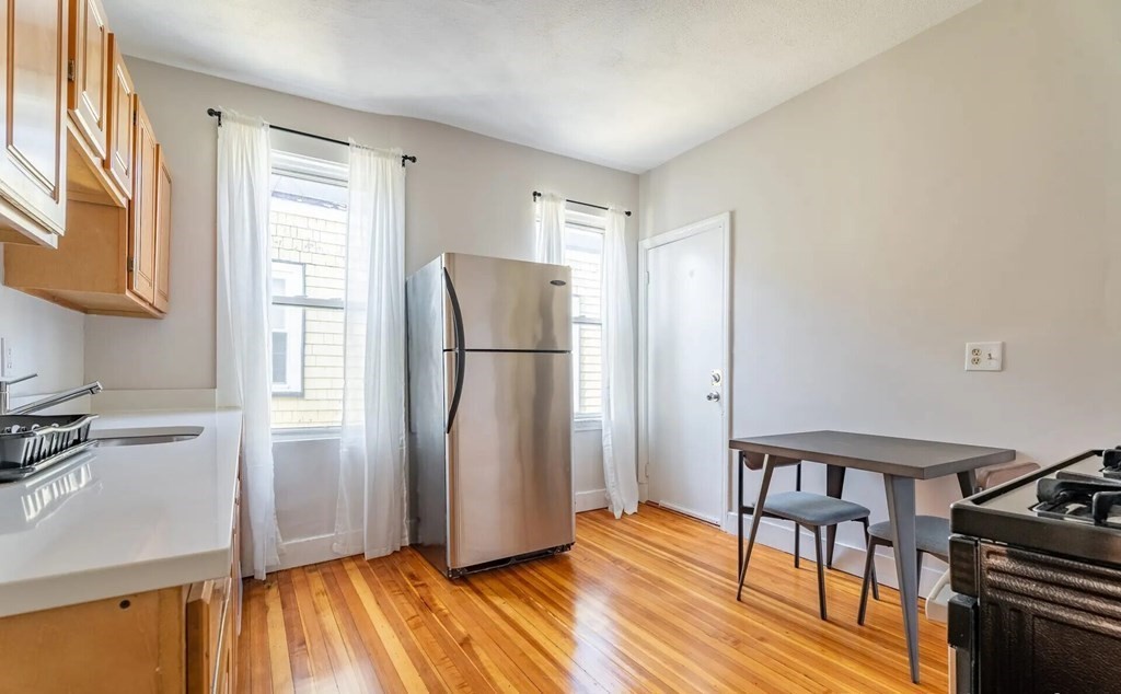 33 Edison Green, Unit 3 Boston, MA 02125 - Photo 2 of 11 a view of a kitchen with furniture refrigerator and wooden floor