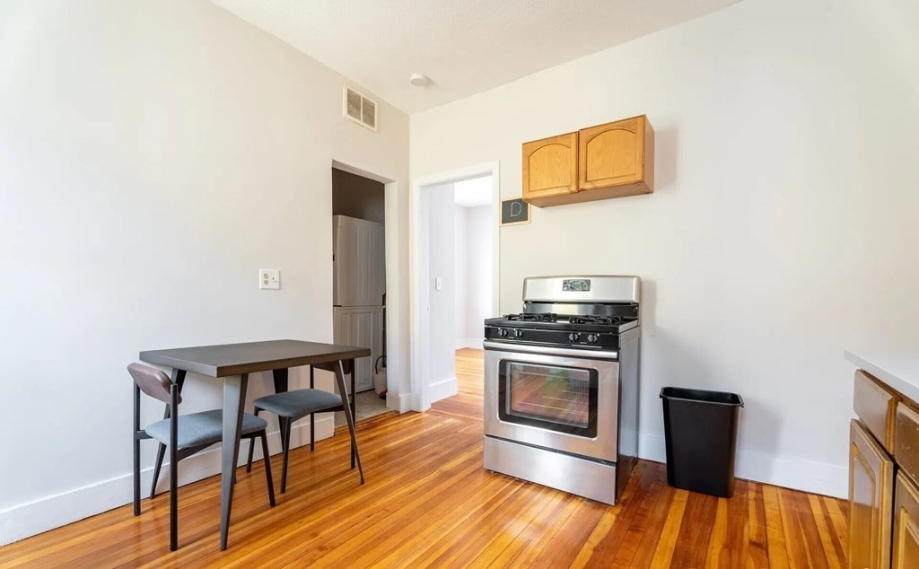 33 Edison Green, Unit 3 Boston, MA 02125 - Photo 3 of 11 a kitchen with granite countertop a stove and a wooden floor