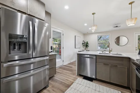 a kitchen with stainless steel appliances granite countertop a sink a stove and refrigerator