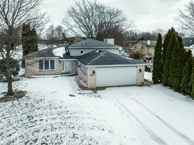 a view of a white house with a yard covered in snow