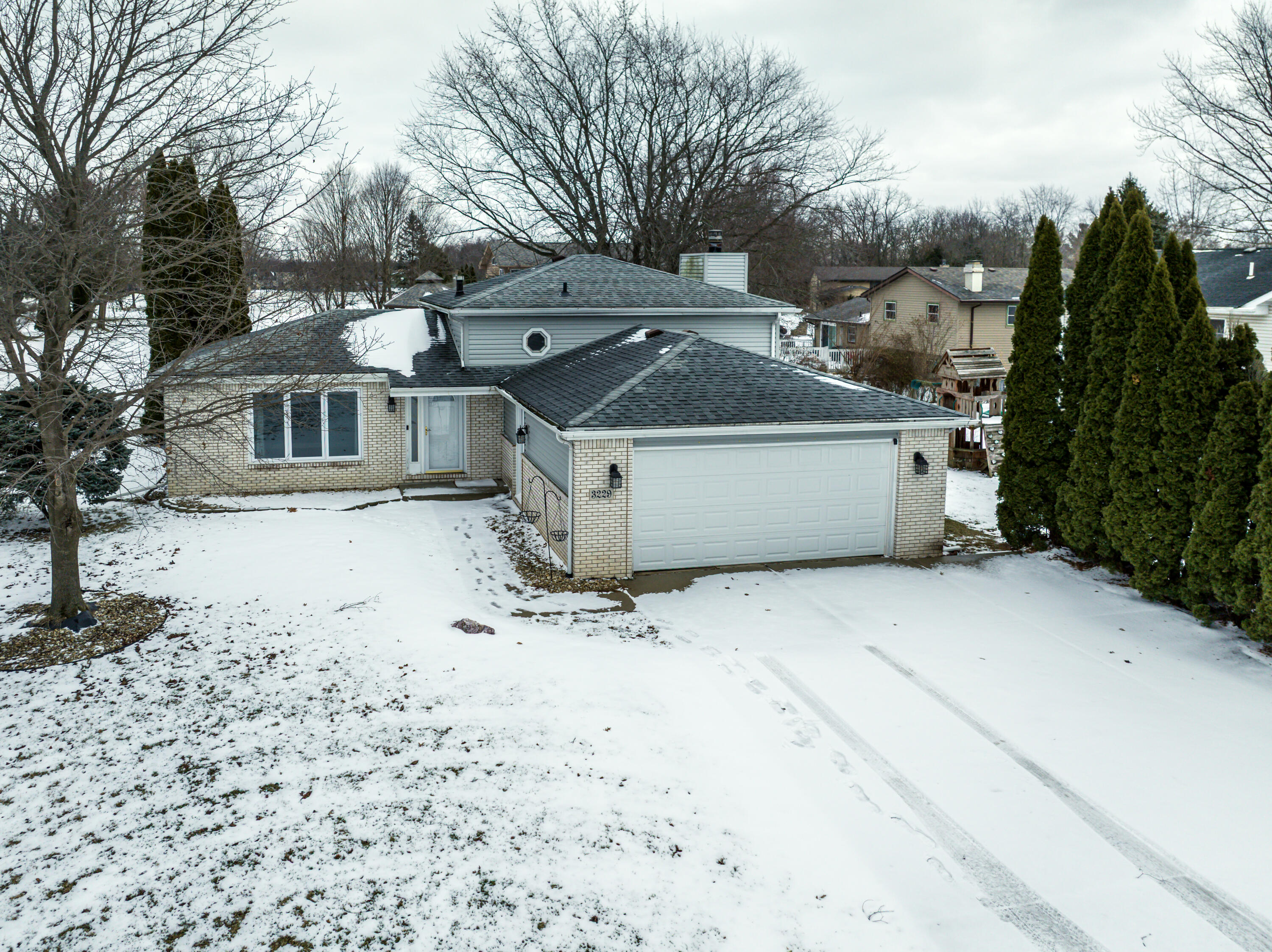 a view of a white house with a yard covered in snow