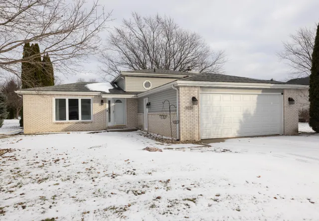 a front view of a house with a yard covered in snow