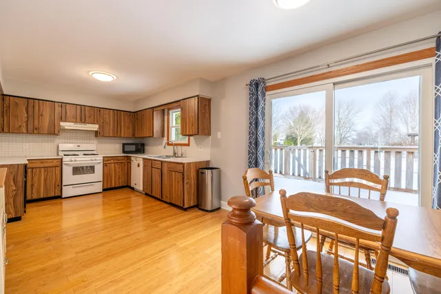 a kitchen with stainless steel appliances wooden floors and white cabinets