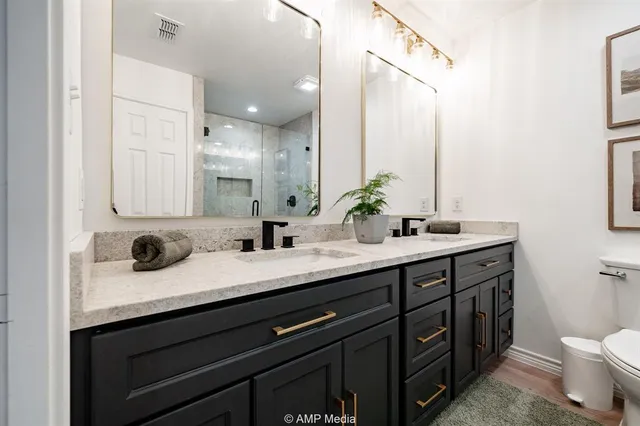 a bathroom with a double vanity sink toilet and shower