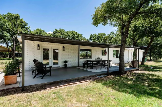 a view of a porch with chairs and potted plants