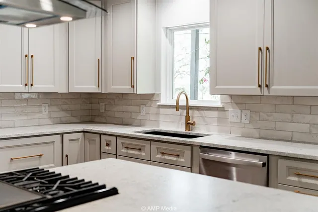 a kitchen with white cabinets and appliances