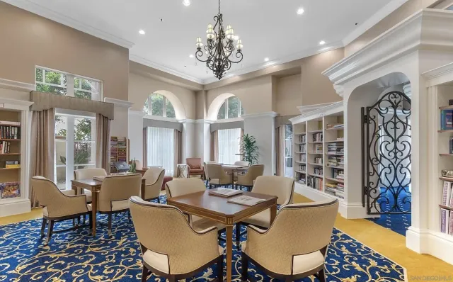 a dining room with wooden floor a chandelier a wooden table and chairs