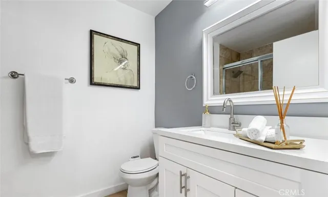 a bathroom with a granite countertop toilet sink and mirror