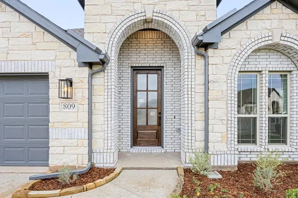 a view of a brick house with large windows