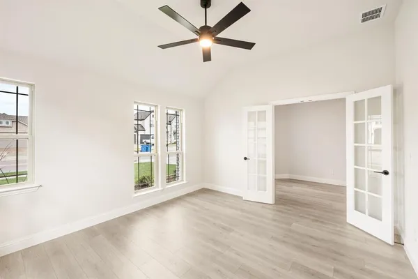 a view of an empty room with a window and wooden floor