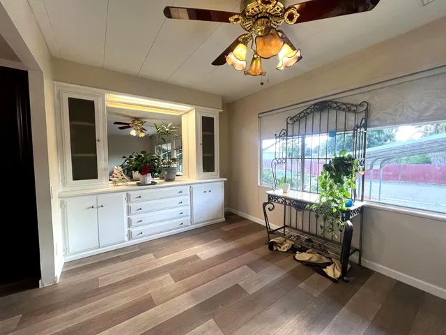 a kitchen with stainless steel appliances granite countertop a refrigerator a sink dishwasher a stove and a dining table with wooden floor