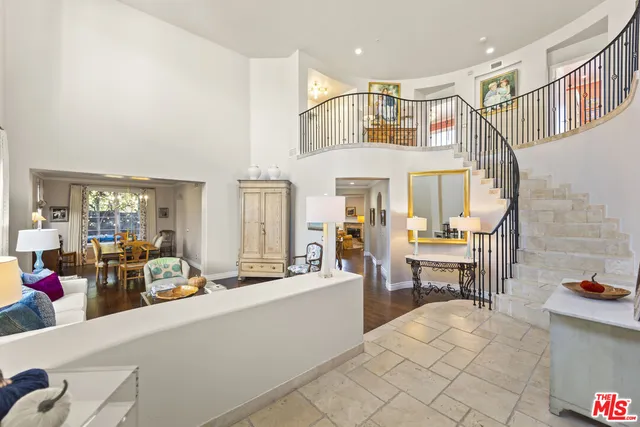 a living room with furniture a fireplace and large windows