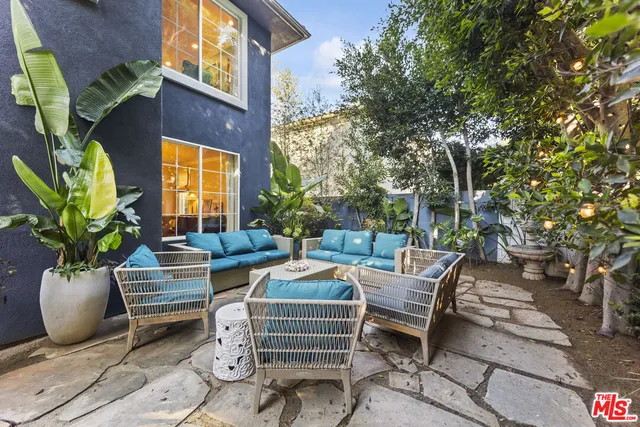 a view of a patio with table and chairs and potted plants