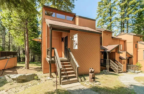 a front view of a house with a tree