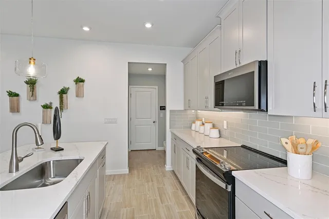 a kitchen with stainless steel appliances granite countertop a kitchen island a stove a dining table and chairs