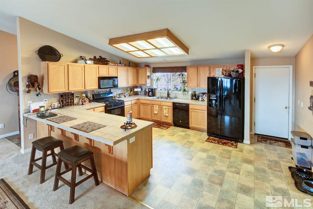4363 Rancheria Road Fallon, NV 89406 - Photo 7 of 21 a kitchen with a stove a refrigerator and a dining table