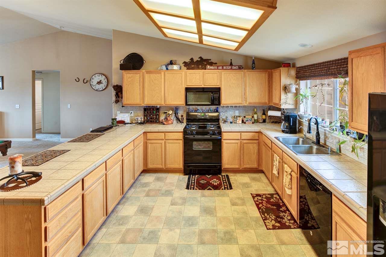4363 Rancheria Road Fallon, NV 89406 - Photo 8 of 21 a large kitchen with stainless steel appliances kitchen island granite countertop a sink counter space cabinets and a large window