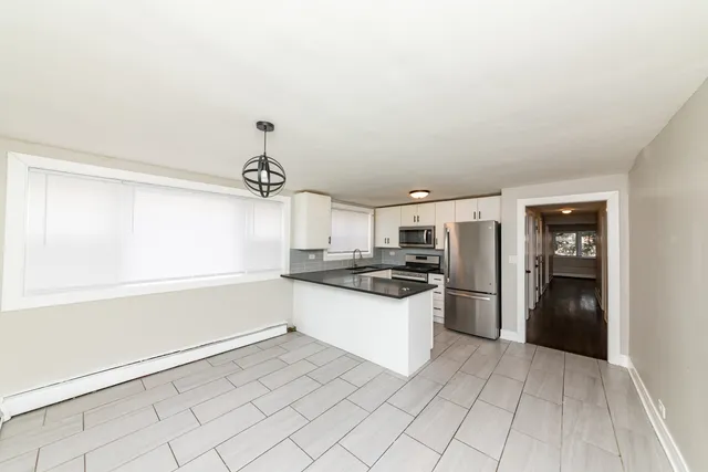 a kitchen with granite countertop a refrigerator and a stove top oven