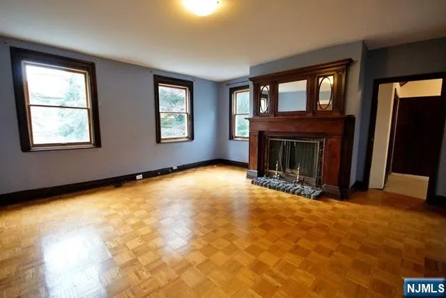 a view of an empty room with window and fire place