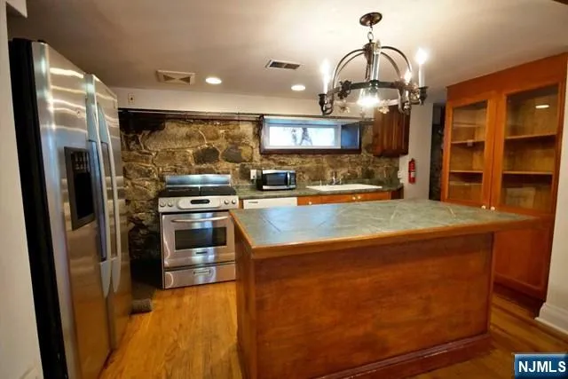 a kitchen with stainless steel appliances granite countertop a sink a stove and a refrigerator