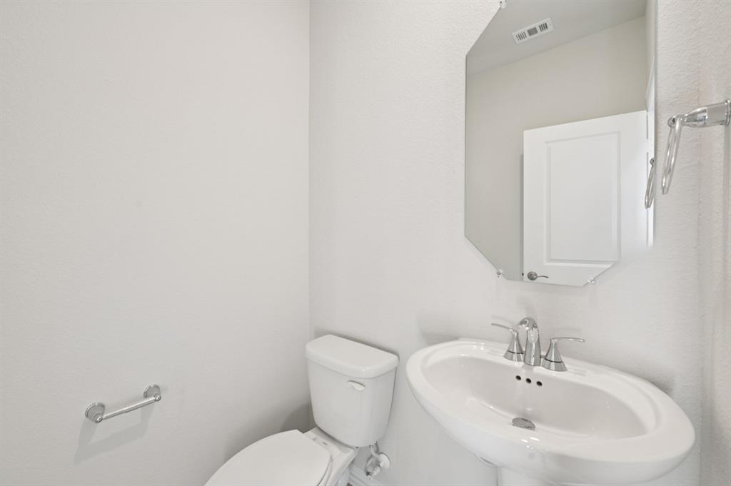 1720 Arches Road Anna, TX 75409 - Photo 15 of 31 a bathroom with a toilet a sink and mirror