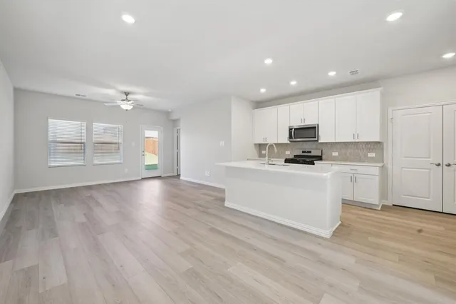 a kitchen with granite countertop white cabinets and wooden floor