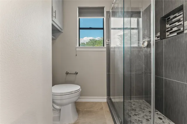 a bathroom with a toilet and a shower