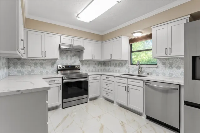 a kitchen with cabinets appliances and a window