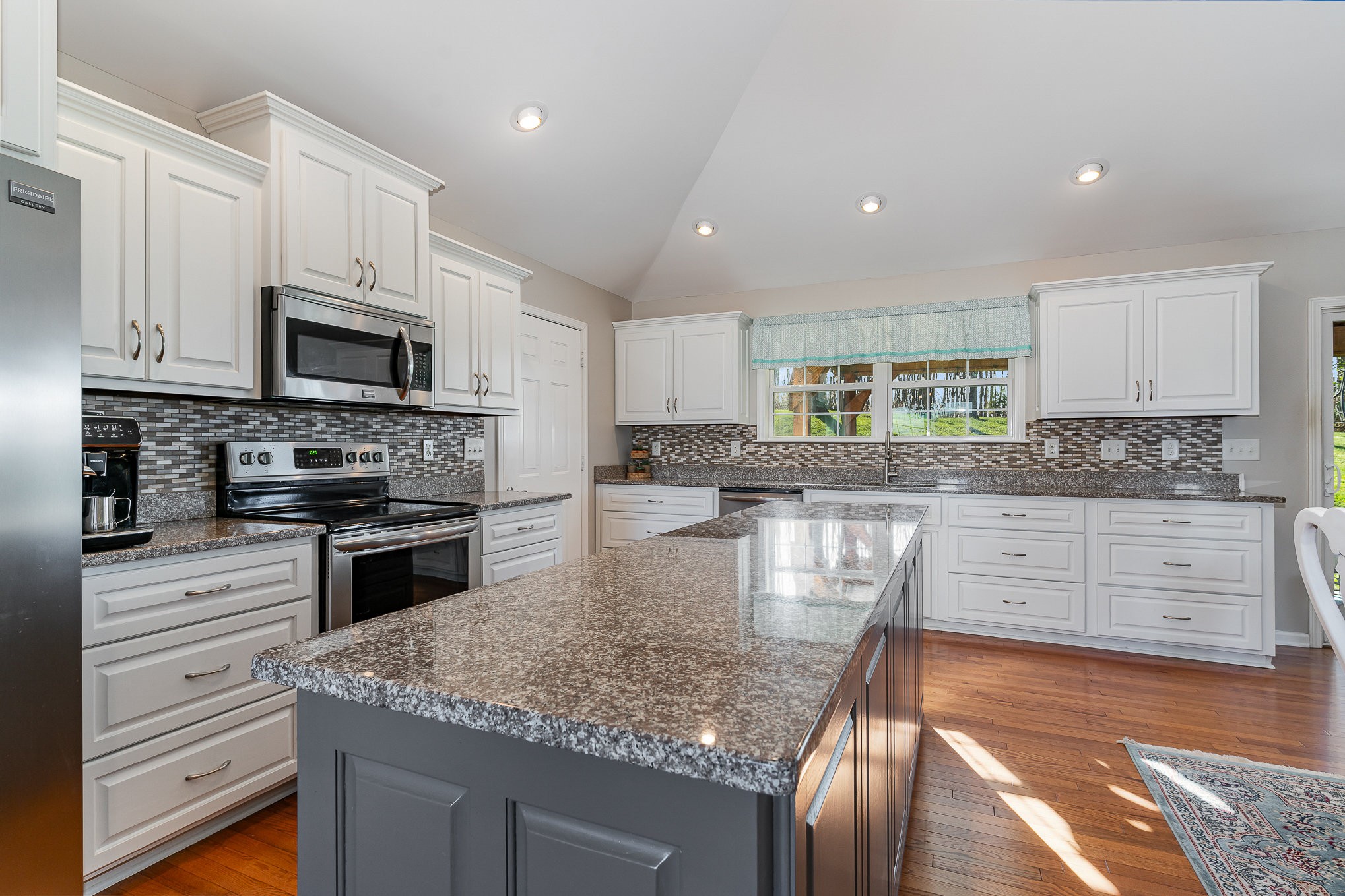 1525 Heller Ridge Spring Hill, TN 37174 - Photo 10 of 57 a kitchen with stainless steel appliances granite countertop a stove top oven a sink dishwasher a refrigerator and white cabinets with wooden floor