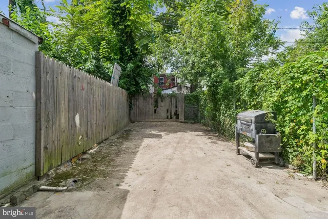 a backyard of a house with chairs and tree