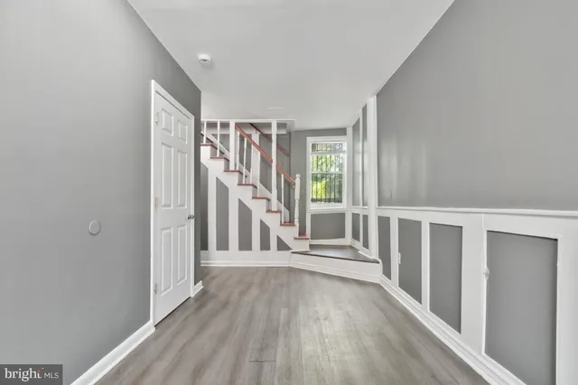 a view of a hallway with wooden floor and entryway