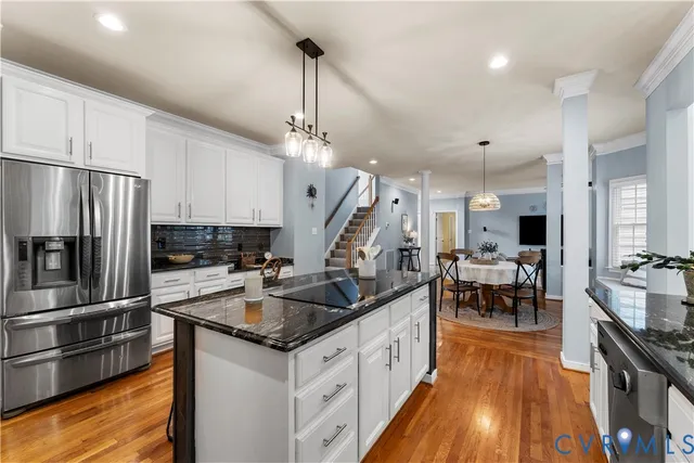 a kitchen with stainless steel appliances granite countertop a sink a stove counter space and cabinets