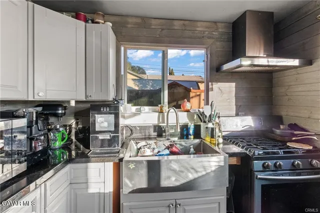 a kitchen with stainless steel appliances granite countertop a stove and a wooden cabinets