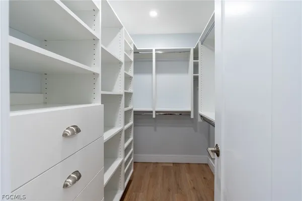 a view of walk in closet with clothes and shoes