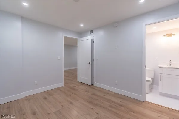 a view of empty room with wooden floor and window