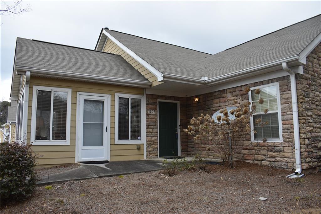2191 Rockbridge Road Southwest, Unit 1302 Stone Mountain, GA 30087 - Photo 1 of 1 a front view of a house with garden