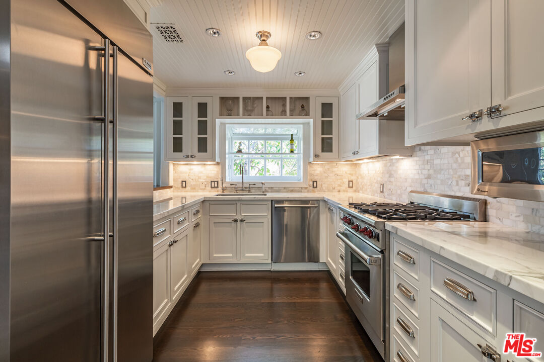1612 Gilcrest Drive Beverly Hills, CA 90210 - Photo 11 of 33 a kitchen with stainless steel appliances granite countertop a stove a refrigerator and a sink