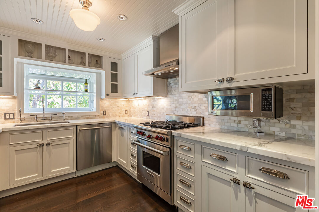 1612 Gilcrest Drive Beverly Hills, CA 90210 - Photo 12 of 33 a kitchen with stainless steel appliances granite countertop a stove and white cabinets
