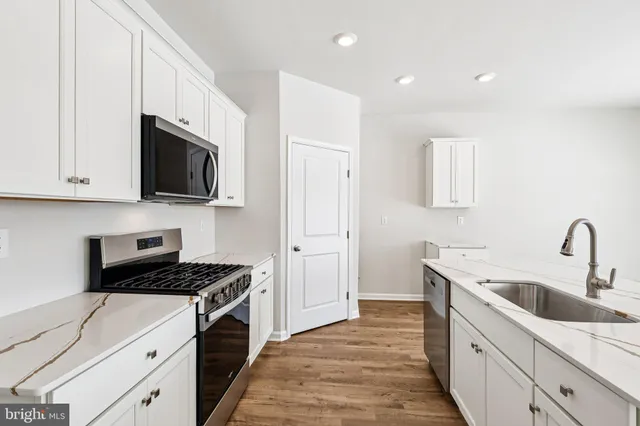 a large white kitchen with wooden floor