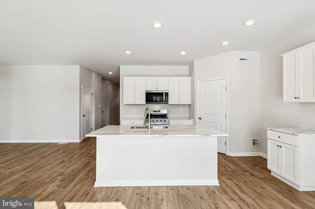 a kitchen with stainless steel appliances a sink stove and cabinets