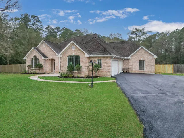 a front view of a house with a garden and yard